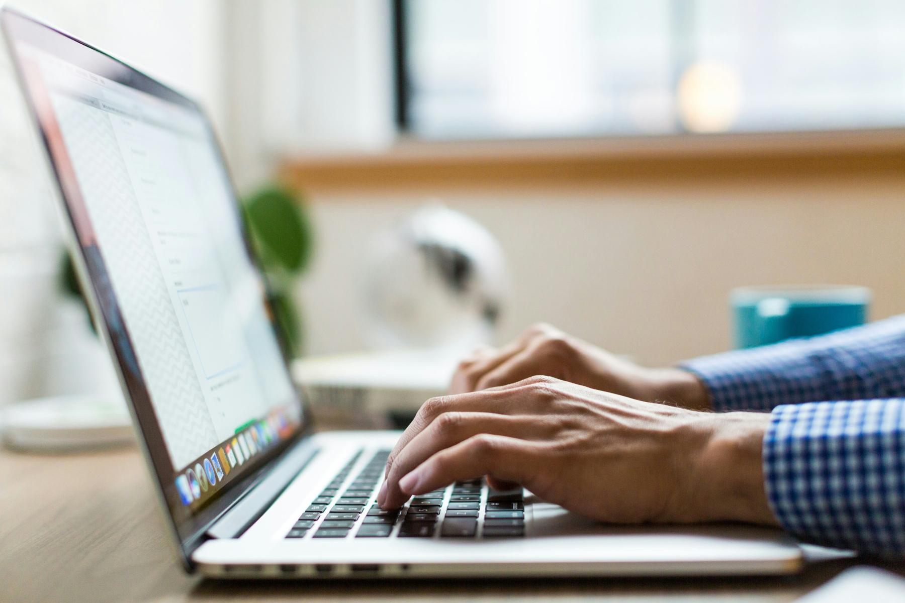 A guy is typing on a laptop keyboard A man is typing on a laptop keyboard